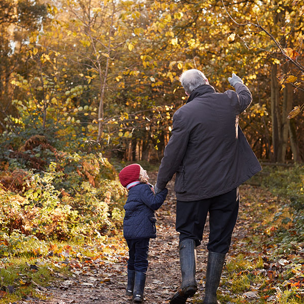grandfather and child walking in woods
